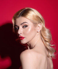 Fototapeta premium Beauty woman with fashion eyes make up, red lipstick on plump lips, blonde hair, close up face. Sensual woman with beautiful face and smooth skin, bare shoulder. Sexy model with natural makeup.