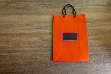 Orange paper bag on wooden background