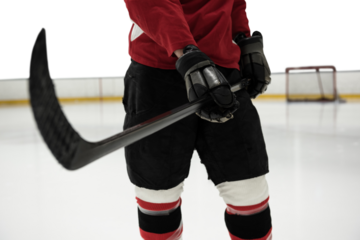 Mid section of hockey player holding stick