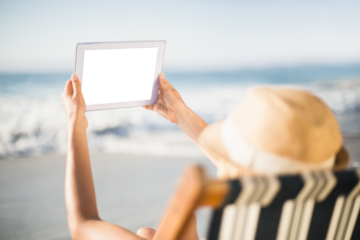 Woman using digital tablet on beach