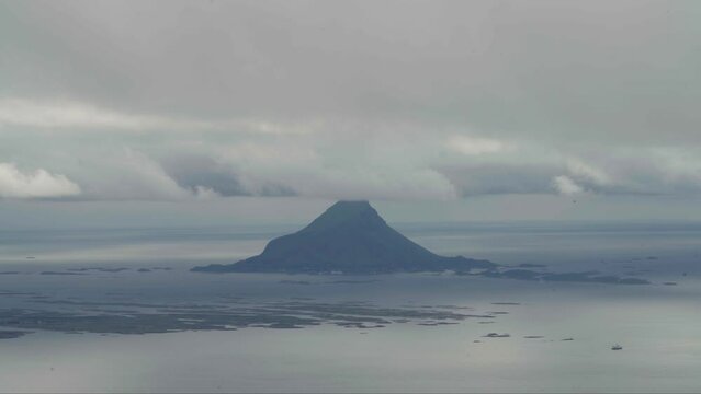 Cloud-Capped Mountainous Island Of Lovund Surrounded By Calm Waters On A Foggy Day In Northern Norway. wide