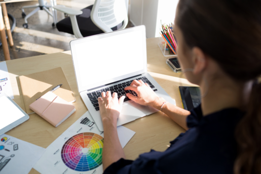 Female executive working over laptop at desk