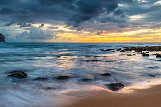 Sunrise with scattered rain clouds at the seaside