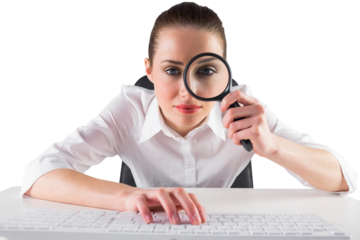 Businesswoman typing and looking through magnifying glass