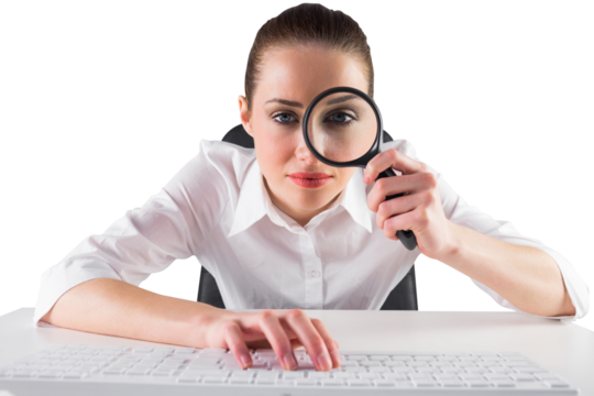 Businesswoman typing and looking through magnifying glass - Powered by Adobe
