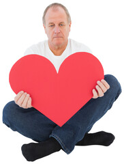 Upset man sitting holding heart shape