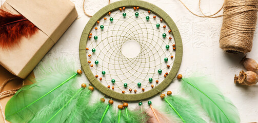 Dream catcher with gift and thread on light background, closeup
