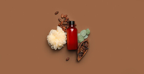 Bottle of shower gel, loofah and cocoa beans on brown background