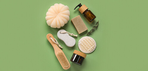 Different bathing supplies and cosmetics on green background