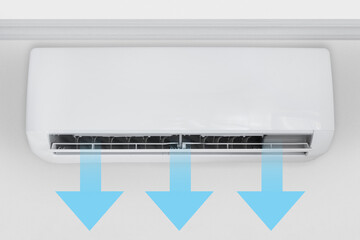 Wall-mounted split air conditioner in a room with cool air flow shown by arrows.