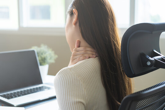 Body muscles stiff problem, ache asian young woman, girl pain neck while sitting work on chair at home, holding massaging rubbing, hurt or sore, Healthcare people, office syndrome .