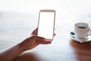 Cropped hand of woman using phone at table