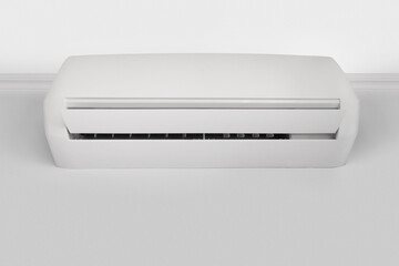 White air conditioner hanging from the ceiling on the wall, copy space.