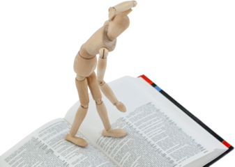 Wooden 3d figurine standing on open book