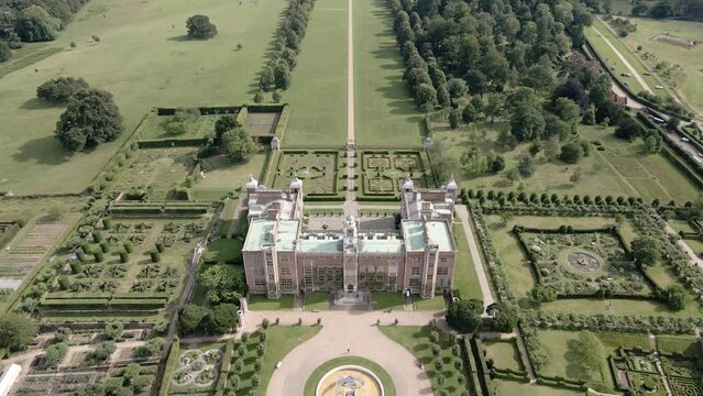 Exterior View Of Hatfield House In A Large Park With Landscaped Gardens In Summer In Hertfordshire, England. - aerial pullback