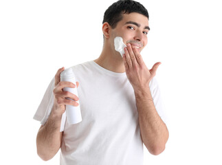 Young man applying shaving foam on face against white background