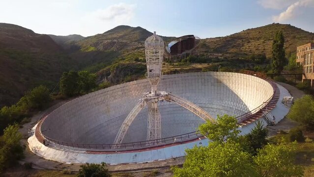 Low Aerial Shot of Mount Aragats Radio Optical Telescope's Herouni Mirror on a Sunny Evening with People Walking towards it, Armenia (UHD)