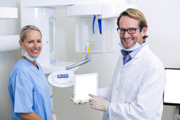 Portrait of dentist and dental assistant working on digital tablet