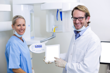 Portrait of dentist and dental assistant working on digital tablet