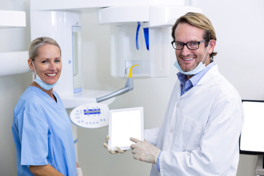 Portrait of dentist and dental assistant working on digital tablet