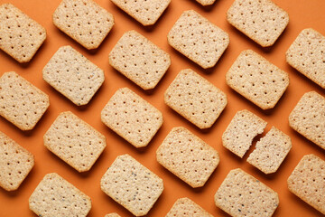 Many tasty crackers on orange background. Concept of uniqueness