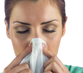 Close-up of woman suffering from blowing nose with tissue