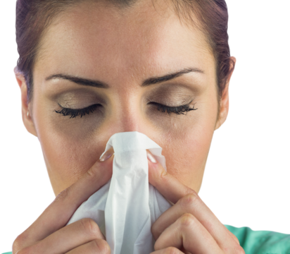 Close-up of woman suffering from blowing nose with tissue