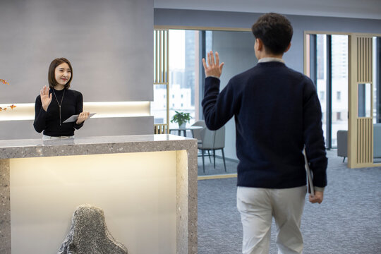 Cheerful Chinese business people greeting in office