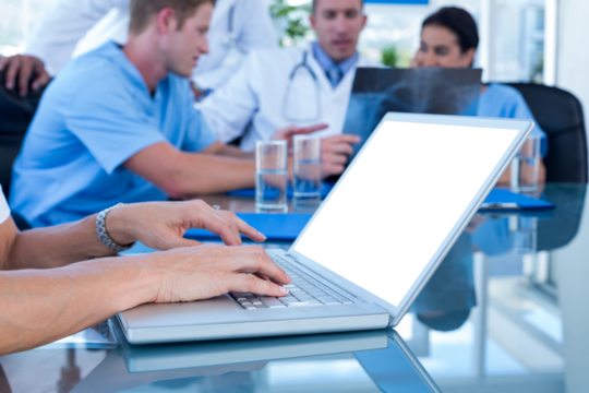 Doctor typing on keyboard with her team behind