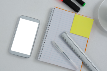 Mobile phone and stationery on white background