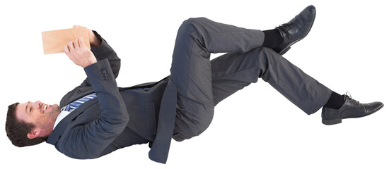 Businessman lying on the floor reading a book