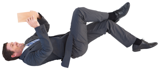 Businessman lying on the floor reading a book