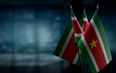 Small flags of the Suriname on an abstract blurry background