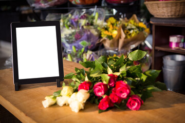 Digital tablet by fresh flowers on table