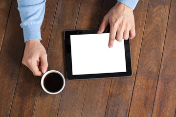 Man using digital tablet while having cup of coffee