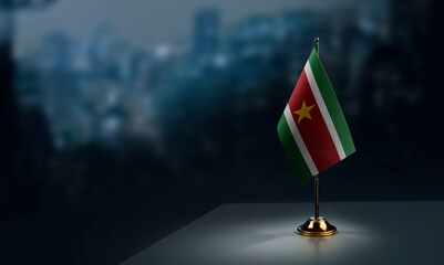 Small flags of the Suriname on an abstract blurry background