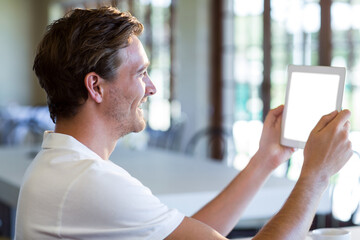 Side view of man holding digital tablet