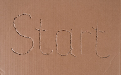 Inscription Start on Textured Craft Cardboard Sheet Surface.