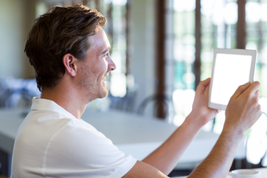 Side view of man holding digital tablet
