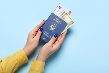 Woman with Ukrainian passport, ticket and money on blue background