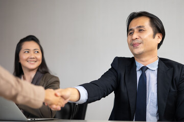 Asian business man shaking hands on a business cooperation agreement. Successful businessmen handshaking after good deal