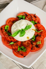 salad with tomato and cheese, salad of chopped tomatoes and buratta cheese in a white rectangular salad bowl