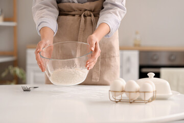 Woman making dough for pasta at table in kitchen, closeup