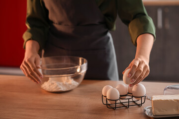 Woman making dough for pasta at table in kitchen, closeup