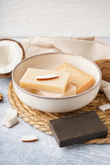 Plate with natural soap bars and coconut on light table
