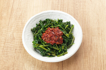 Plecing Kangkung or Brambang Asem, made from boiled spinach served with chili sauce (sambal), spicy and sour. Indonesian food
