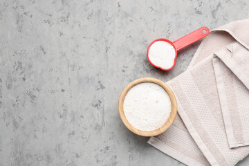Laundry detergents and towel on grey grunge background