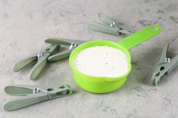 Laundry detergent and clothespins on grunge grey background