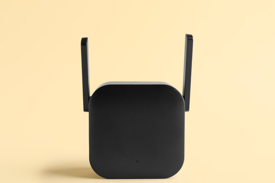 Black WiFi repeater on beige background