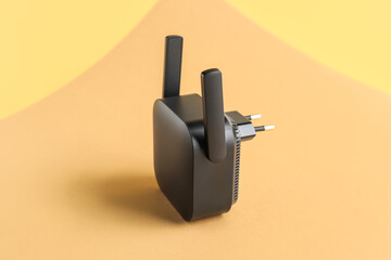 Black WiFi repeater on beige background
